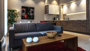 A modern living room with a grey sofa, a wooden coffee table, and a red rug. - Forenom Serviced Apartments Bergen City (Bergen)