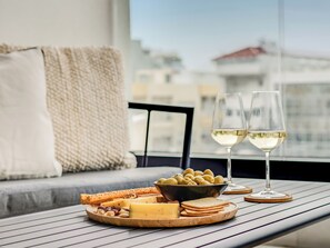 A table with a cheese platter, crackers, olives, and glasses of white wine. - Sanders Premier Downtown - Full Building (Limassol)