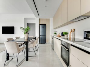 A modern kitchen with a built-in oven, a dishwasher, and a refrigerator. - Sanders Premier Downtown - Full Building (Limassol)