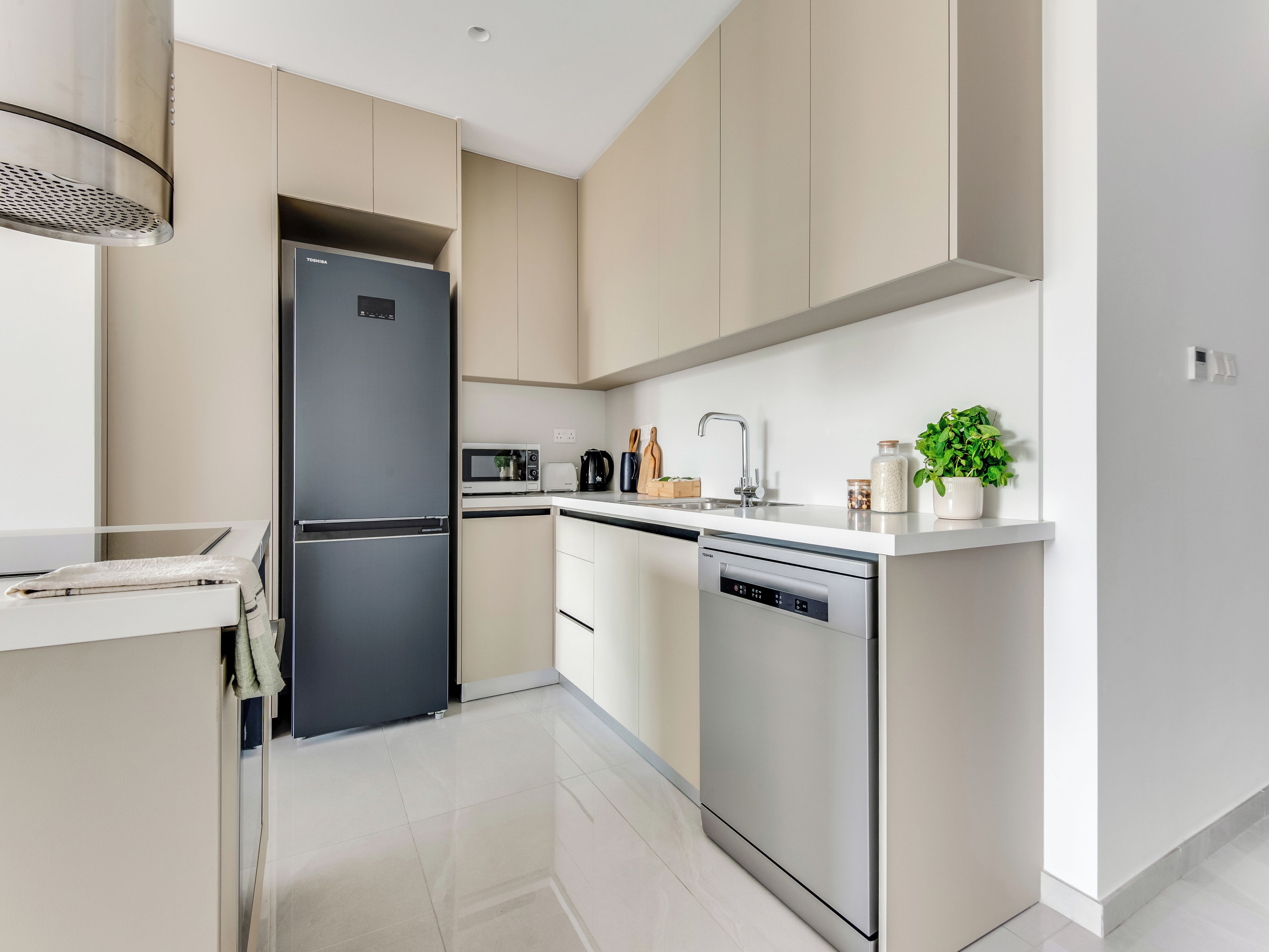 Una cocina moderna con un refrigerador negro, un microondas, un lavavajillas y un fregadero.