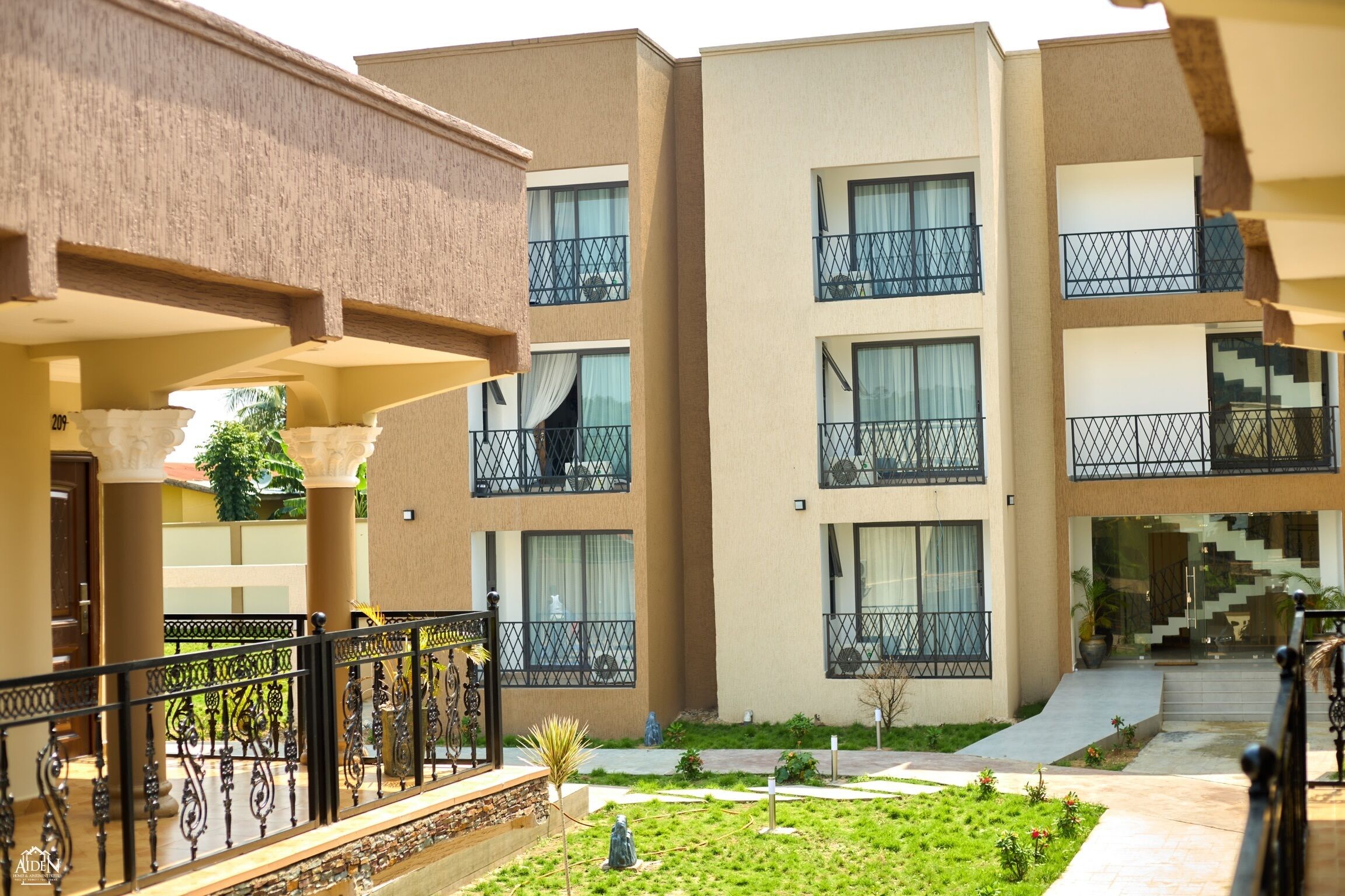 A multi-story hotel with balconies, a central courtyard, and a staircase leading to the upper floors.