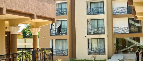 A multi-story hotel with balconies, a central courtyard, and a staircase leading to the upper floors.