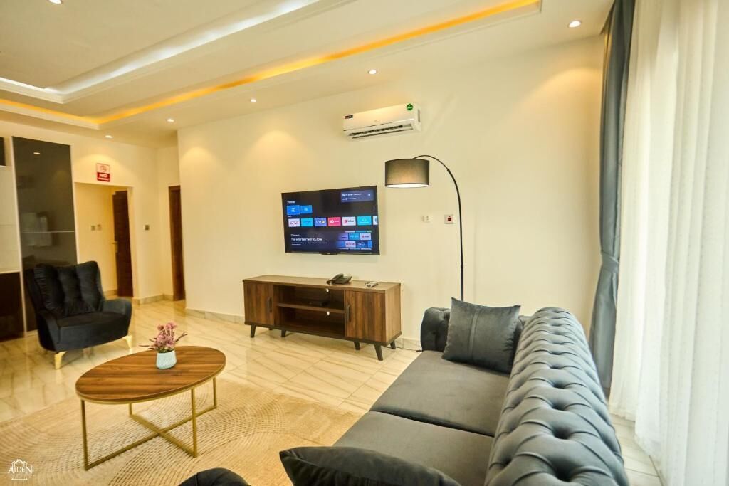 A modern living room with a sofa, a coffee table, a TV, and a cabinet.