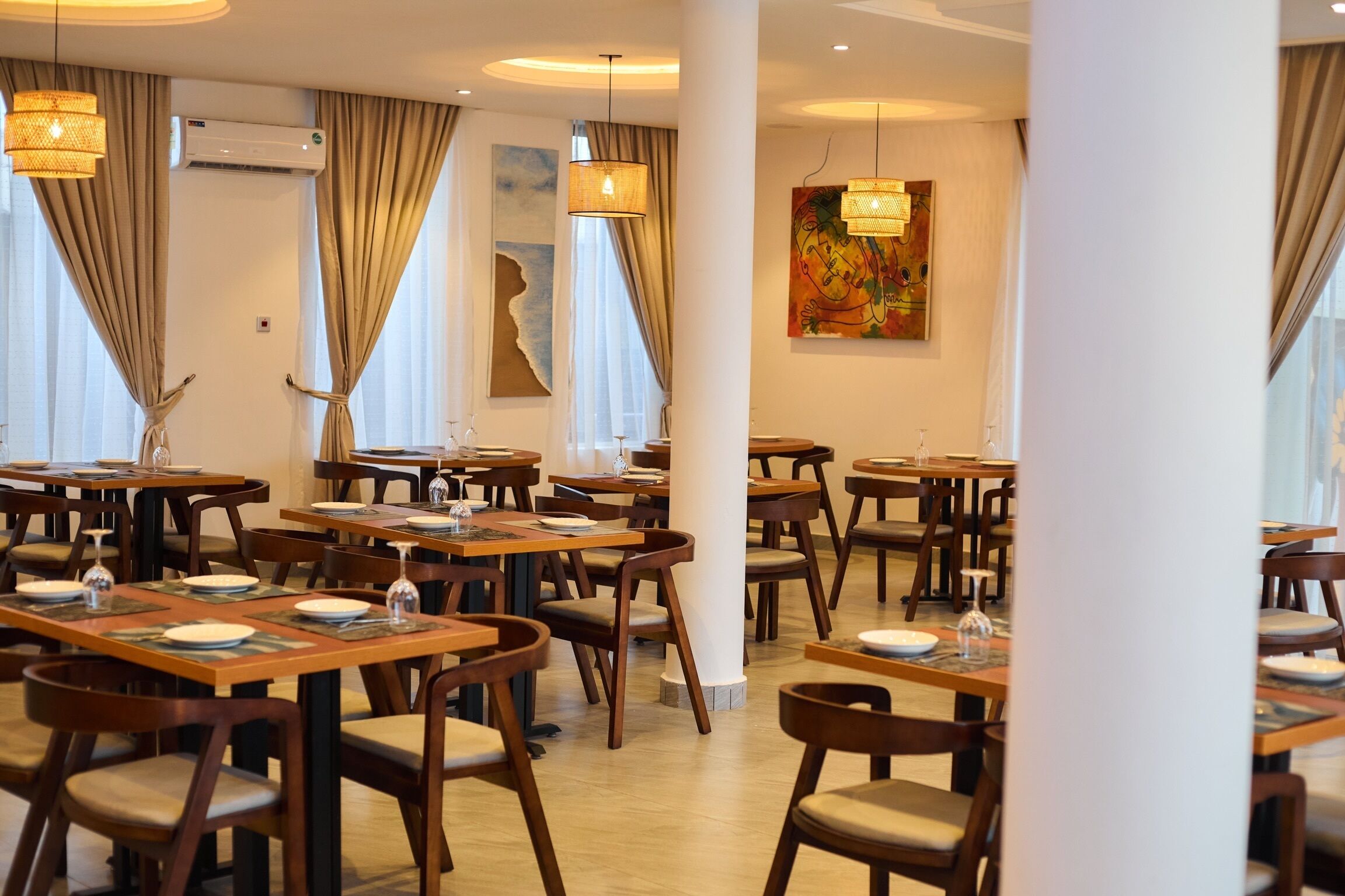 A restaurant with multiple tables and chairs, arranged in a spacious layout.