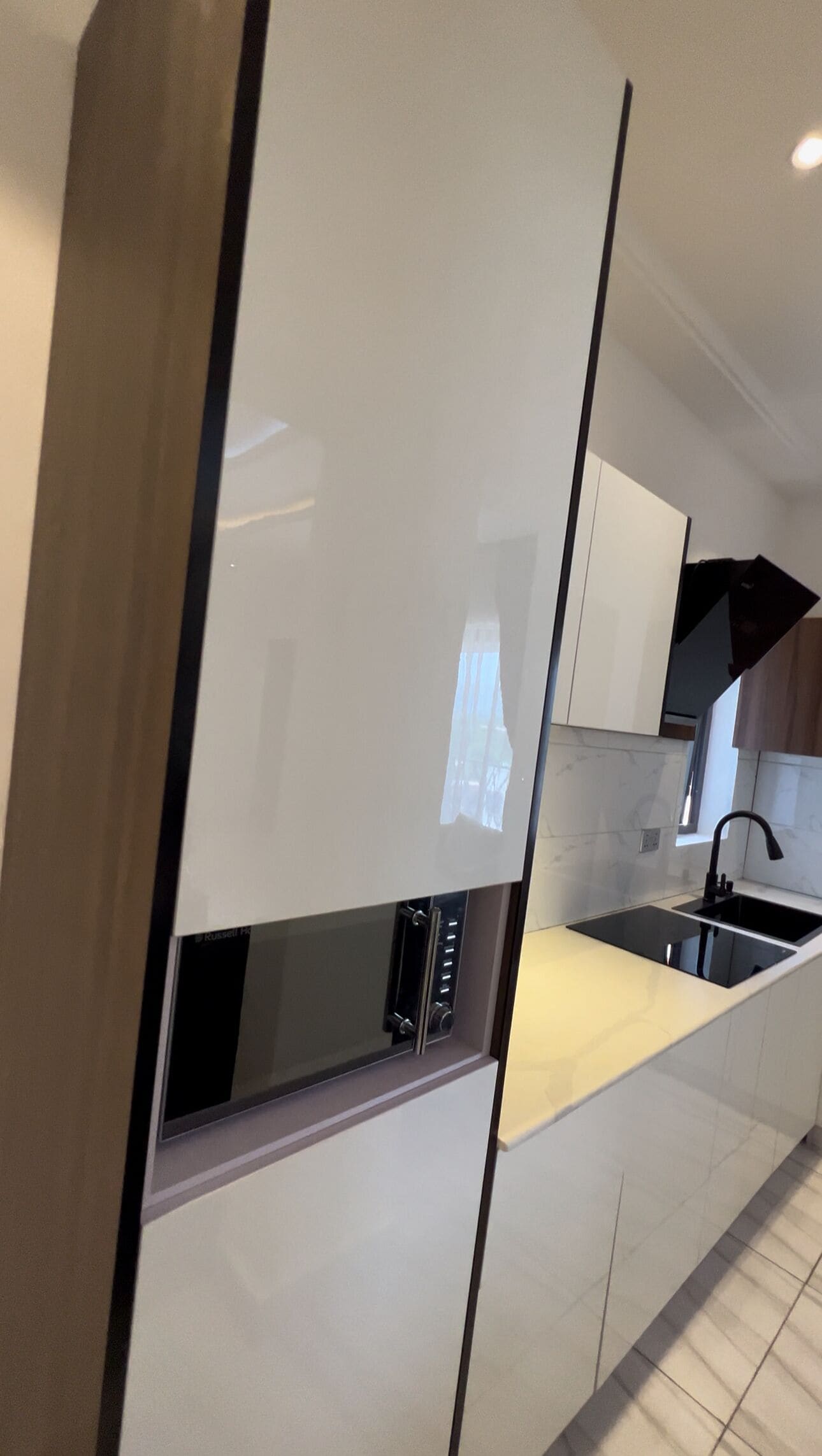 Una cocina moderna con un diseño elegante, que incluye un horno empotrado y un lavamanos de acero inoxidable.