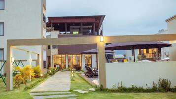 A modern building with a covered outdoor area, a pathway, and outdoor seating.