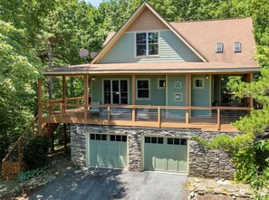 A two-story house with a stone foundation, a covered porch, and a garage. - Point of View with Hot Tub, Mtn Views and Fire Pit (Fairview)