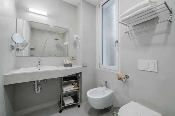 A modern bathroom with a sink, mirror, towel rack, and toilet. - Milano Ticinese Guest House (Milan)