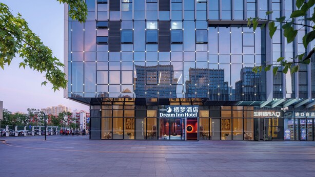 A modern hotel with a glass facade, a visible entrance, and a sign indicating it is the Dream Inn Hotel. - Beijing Dream Inn Hotel (Beijing)