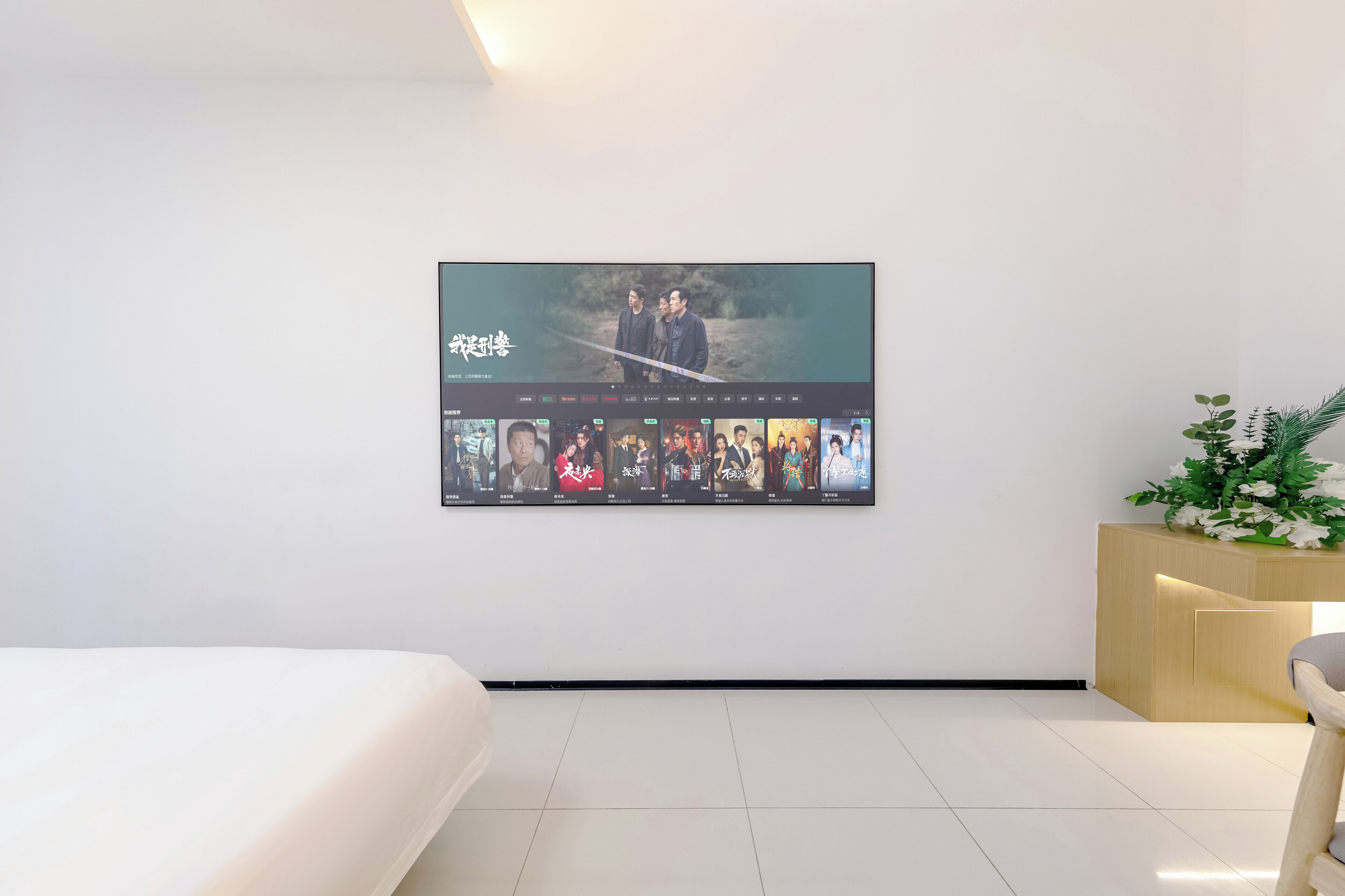 Une chambre d’hôtel moderne dotée d’un grand écran numérique affichant une sélection de films.