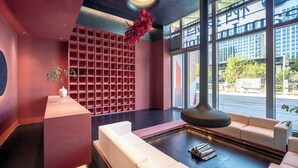 A modern lobby with a seating area, a large window, and a decorative plant. - Beijing Dream Inn Hotel (Beijing)