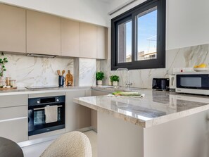 Una cucina moderna con forno integrato, microonde e lavello.