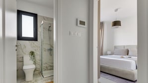 Un bagno moderno con box doccia in vetro, un water e pavimento in marmo.