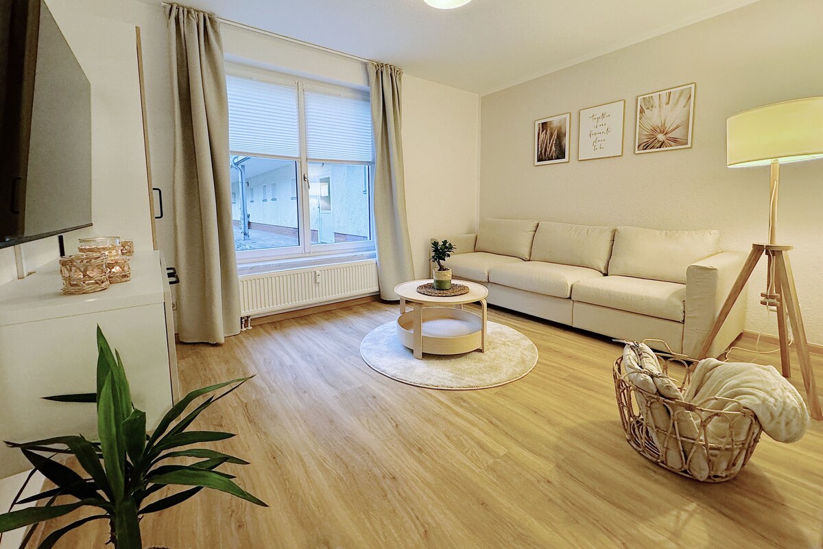 A living room with a sofa, a coffee table, a TV, and a lamp.