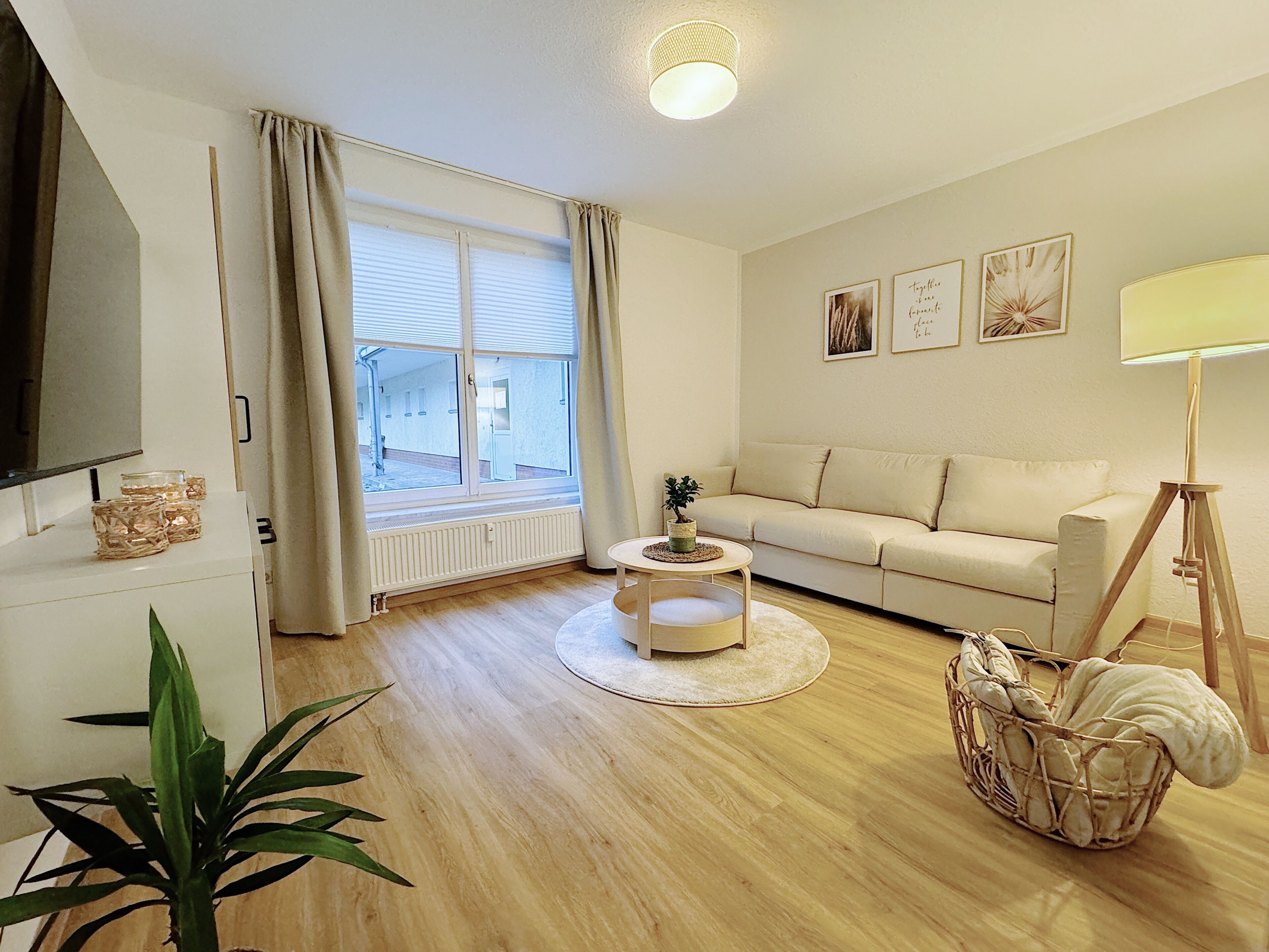 Un salon avec un canapé, une table basse, un téléviseur et une lampe.