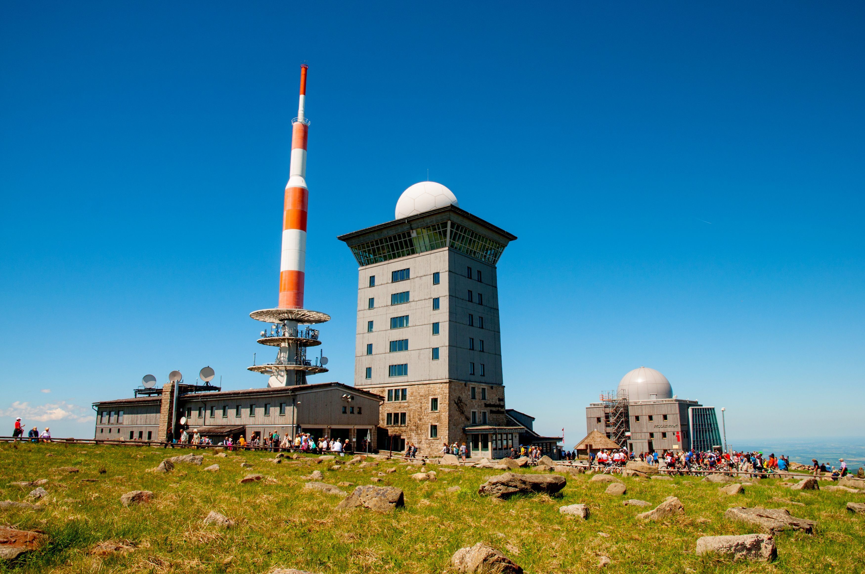 Een groot gebouw met meerdere verdiepingen en een opvallende toren met een bolvormige koepel.