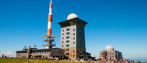 Ein großes Gebäude mit mehreren Stockwerken und einem markanten Turm mit einer kugelförmigen Kuppel.