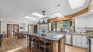 A spacious kitchen with a large island, wooden accents, and ample natural light from skylights. - Rustic Retreat - Near downtown, lake parks & hospital - Hot tub - 5 bd (McCall)