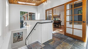 A staircase with a handrail, a wooden ceiling, and a view of a dining area. - Rustic Retreat - Near downtown, lake parks & hospital - Hot tub - 5 bd (McCall)