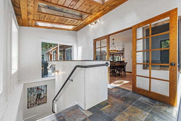 A staircase with a handrail, a wooden ceiling, and a view of a dining area. - Rustic Retreat - Near downtown, lake parks & hospital - Hot tub - 5 bd (McCall)