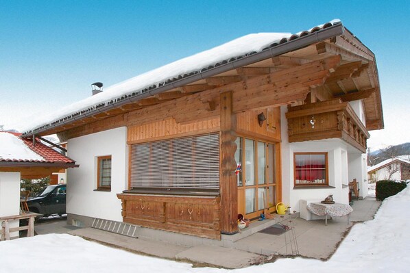 A wooden chalet with a balcony, large windows, and a snow-covered roof. - Holiday Home, Axams (Axams)