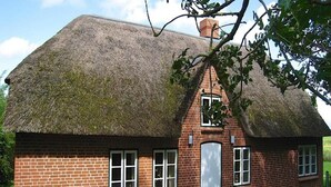 A traditional brick house with a thatched roof and a chimney. - Ferienhaus in Westerhever mit Garten (Westerhever)