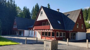 A red and white building with a sloped roof, a covered porch, and a sign in front. - Nice Apartment in Breitenbrunn With Sauna (Breitenbrunn/Erzgeb.)