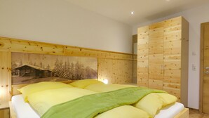 Una camera da letto con una testiera in legno, un letto con molti cuscini, un armadio e una porta.