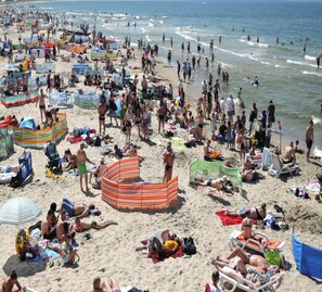 A crowded beach with numerous people, umbrellas, and beach chairs. - Holiday Home in Rewal Near Sandy Beach (Rewal)