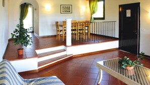 Un vaste espace de vie agrémenté d’un escalier en bois, d’une table à manger avec des chaises et d’une plante en pot.