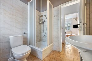A modern bathroom with a toilet, shower, and sink. - Reihenhaus mit Wlan in Buchholz am Muritzsee (Buchholz)