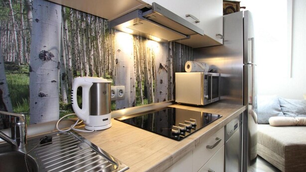 Una cocina moderna con estufa integrada, hervidor, tostadora y refrigerador.