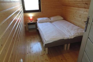 A small, single-bed room with wooden walls and a window. - Terraced House in Rewal Near Sandy Beach (Rewal)