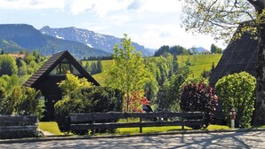 Un paysage rural avec une cabane en bois, un banc et un poteau d’hydrant.