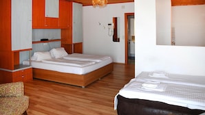 Een slaapkamer met twee bedden, houten vloeren, een kledingkast en een spiegel.