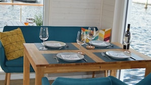 Een eettafel gedekt voor twee met uitzicht op het water en boten.