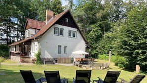 A two-story house with a patio area featuring outdoor furniture. - Ferienhaus, Schorfheide (Schorfheide)
