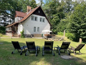 A two-story house with a patio area featuring outdoor furniture. - Ferienhaus, Schorfheide (Schorfheide)