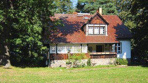 A two-story house with a sloped roof, a front porch, and a stone foundation. - Ferienhaus, Schorfheide (Schorfheide)