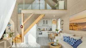 A spacious living area with a high ceiling, a wooden staircase, a kitchen, and a dining area. - Comfortable House With, Whirlpool Bathtub Wrzosowo (Kamien Pomorski)