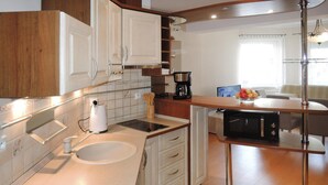 A modern kitchen with white cabinets, a built-in oven, a coffee maker, and a microwave. - Holiday Flat in Miedzyzdroje, top Location for 4 Persons (Miedzyzdroje)