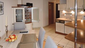 A compact kitchen with a dining area, featuring a cabinet with glass doors, a small refrigerator, and a sink. - Holiday Flat in Miedzyzdroje, top Location for 4 Persons (Miedzyzdroje)
