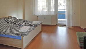 A bedroom with a bed, a window with curtains, a radiator, and a view of the outside. - Holiday Flat in Miedzyzdroje, top Location for 4 Persons (Miedzyzdroje)