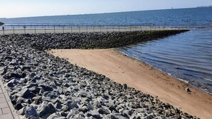 Eine felsige Küstenlinie mit einem gepflasterten Weg zum Wasser.