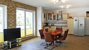 Una cucina moderna con zona pranzo, ampie finestre e televisore a schermo piatto.