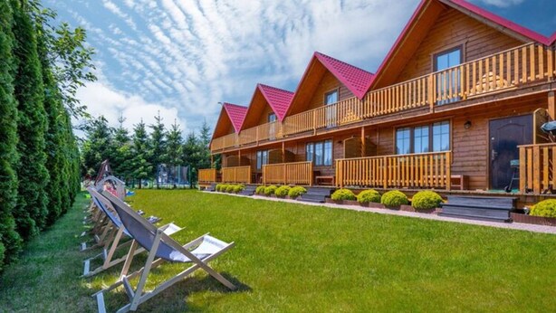 Eine Holzhütte mit mehreren Balkonen und einem gepflegten Rasen.