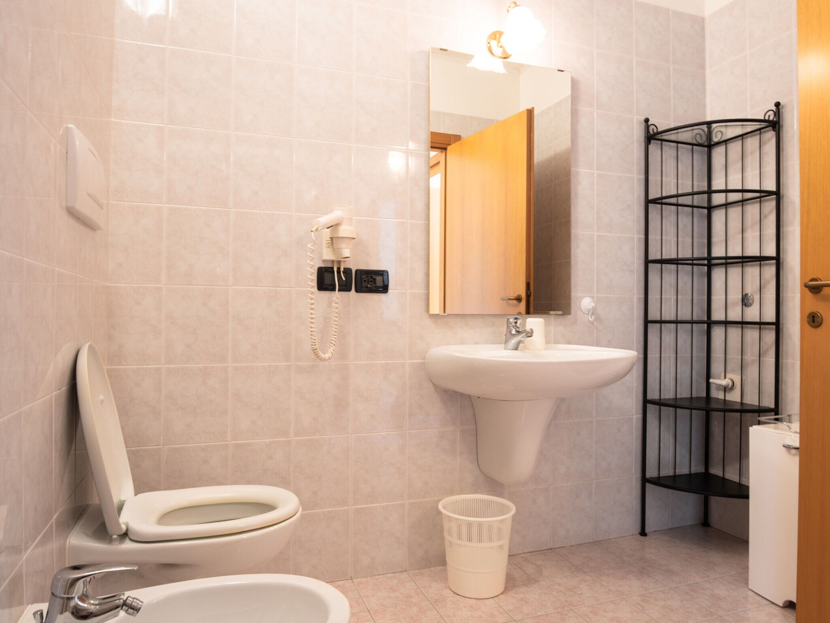 Ein Badezimmer mit Toilette, Waschbecken und Duschbereich.