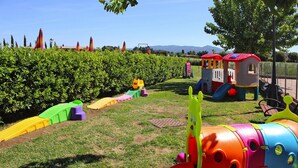 Ein Spielplatz mit bunten Spielgeräten und einem umzäunten Bereich.