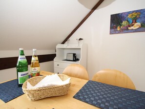 Enjoy a warm and inviting space with a dining table, wall-mounted shelf, and a beautiful painting.