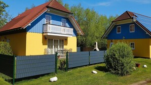 A two-story house with a balcony, a fenced yard, and a small garden. - Ferienhauser am Kummerower See, Verchen (Verchen)